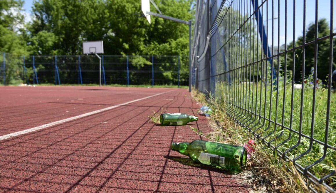 Puste butelki na boisku w parku przy ul. Prufferów w Toruniu