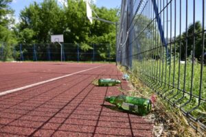Puste butelki na boisku w parku przy ul. Prufferów w Toruniu