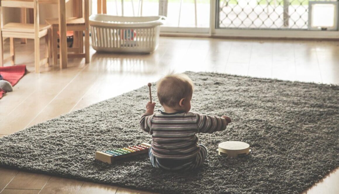 Małe dziecko bawiące się na dywanie
