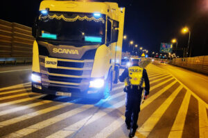 Policjant kontroluje samochód ciężarowy
