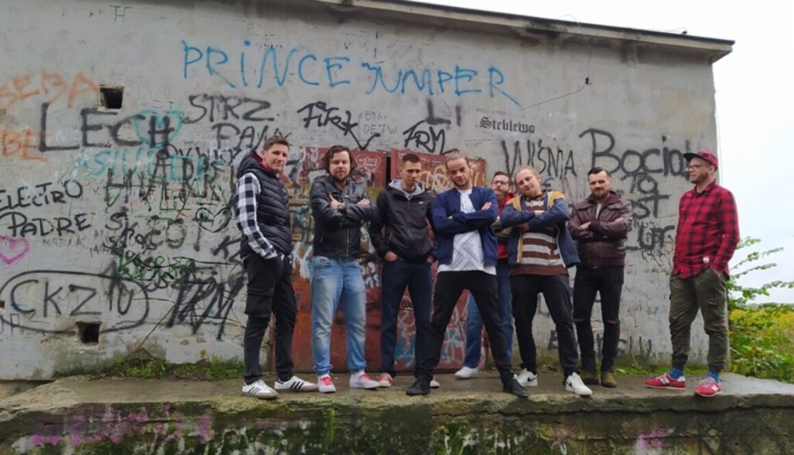 Członkowie zespołu Myasta na tle betonowej ściany z graffiti